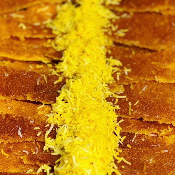 Close-up of golden Persian tahdig with a stripe of yellow saffron rice down the center.
